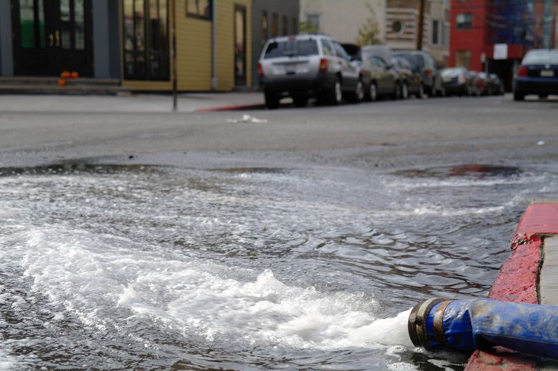 Hose pumping water out of a flooded basement