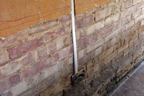 Plaster stripped from a wall during rising-damp treatment